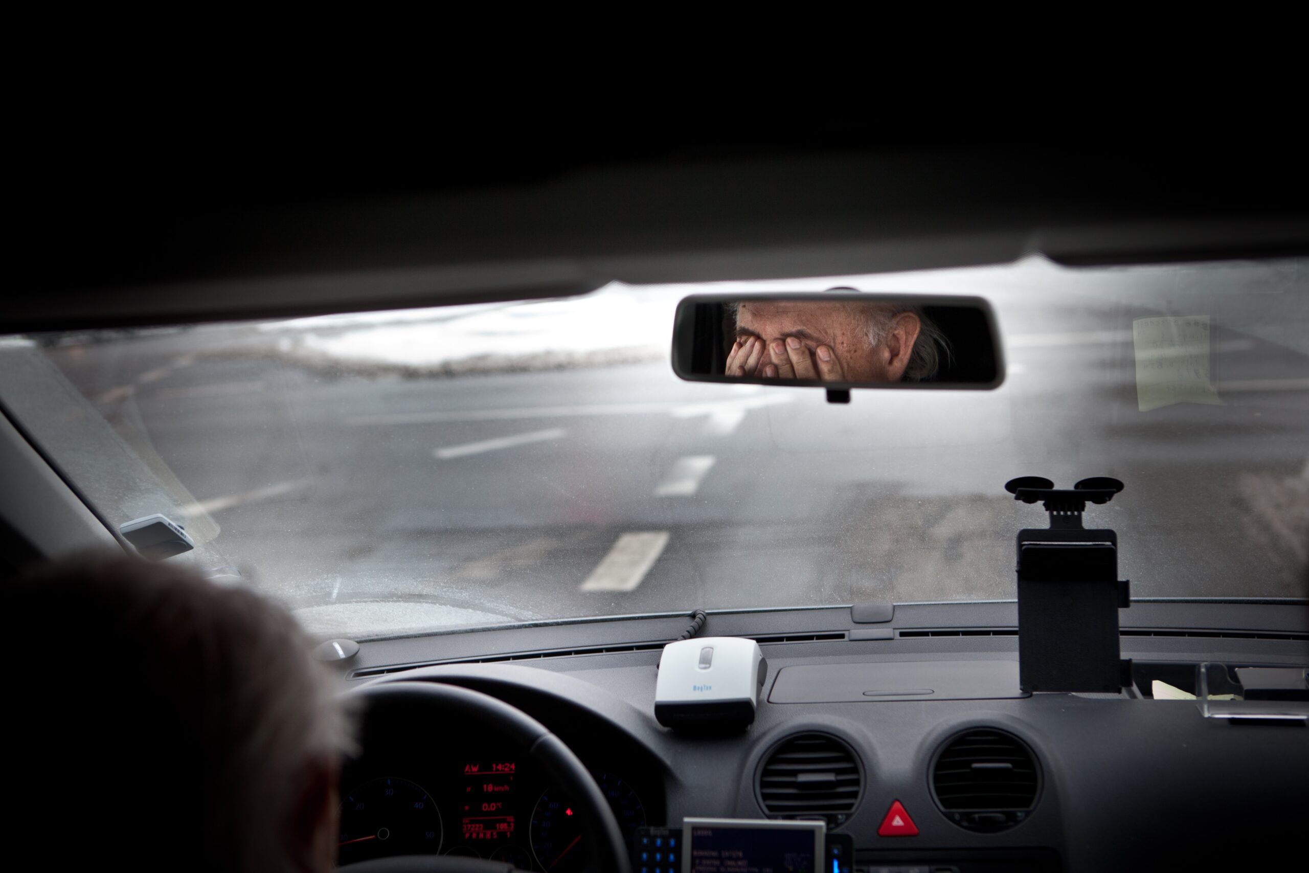 A fatigued driver rubbing his eyes