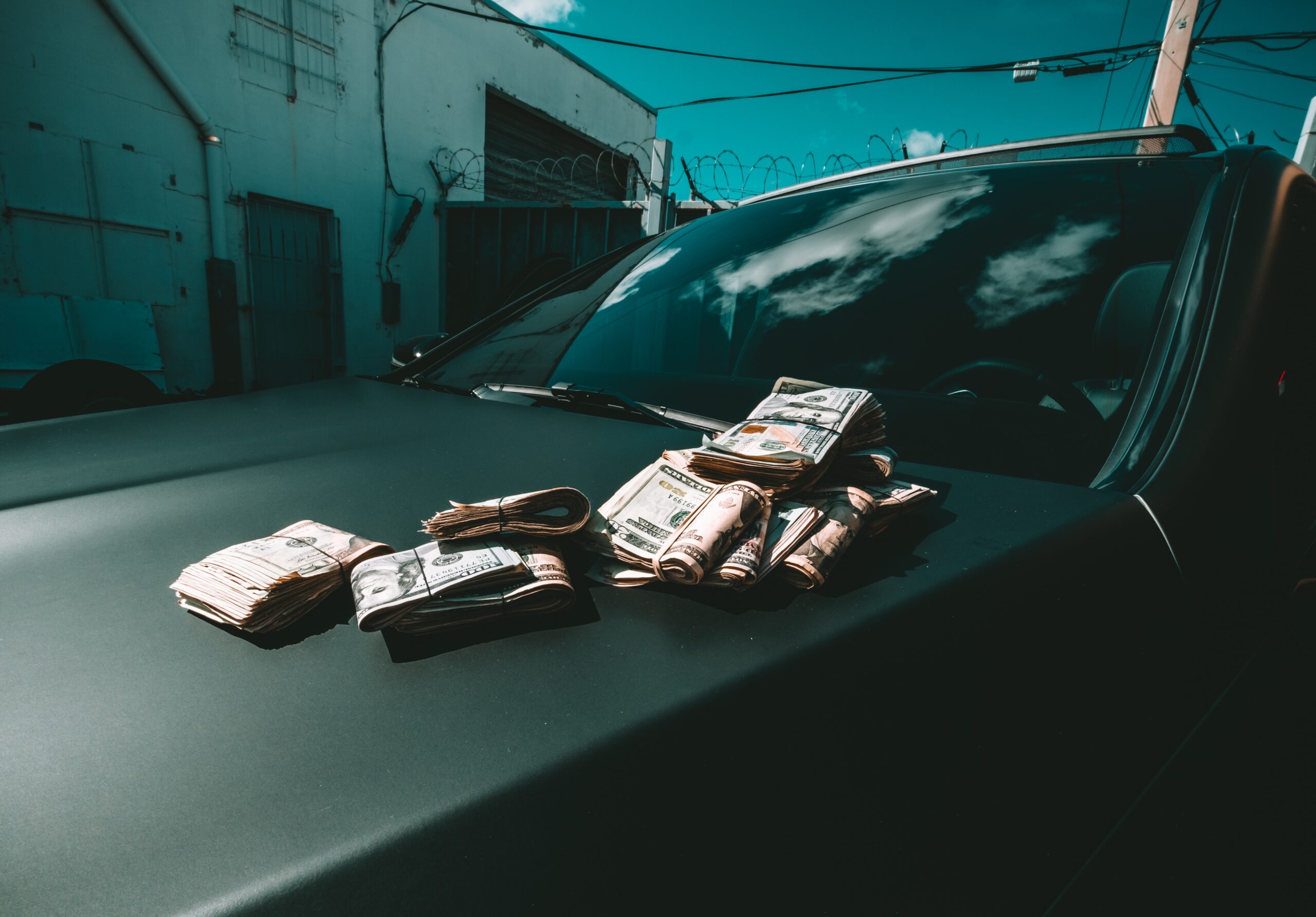 stacks of folded cash on a car hood