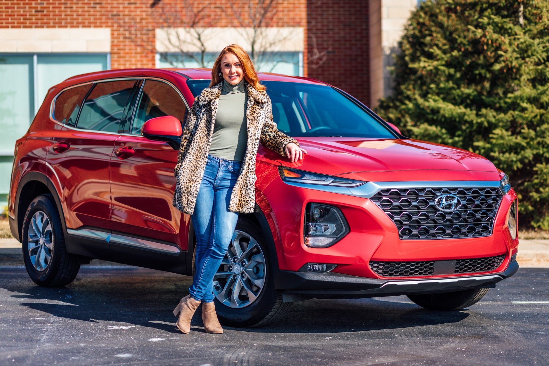 A woman standing in front of a new car