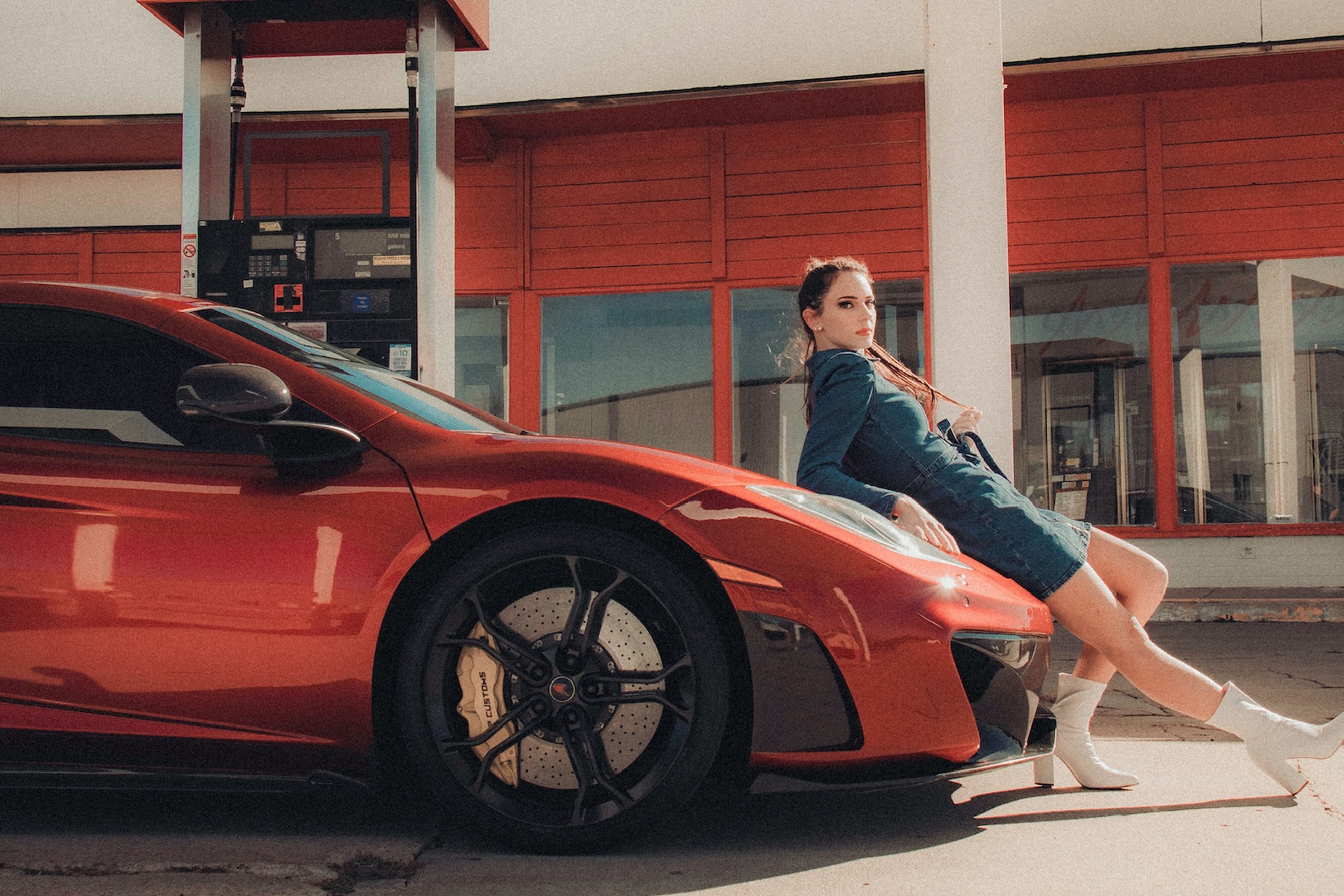 Woman leaning on a red Ferrari