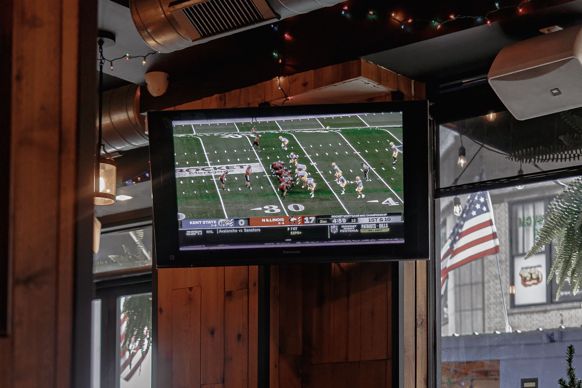 A football game playing on a bar TV