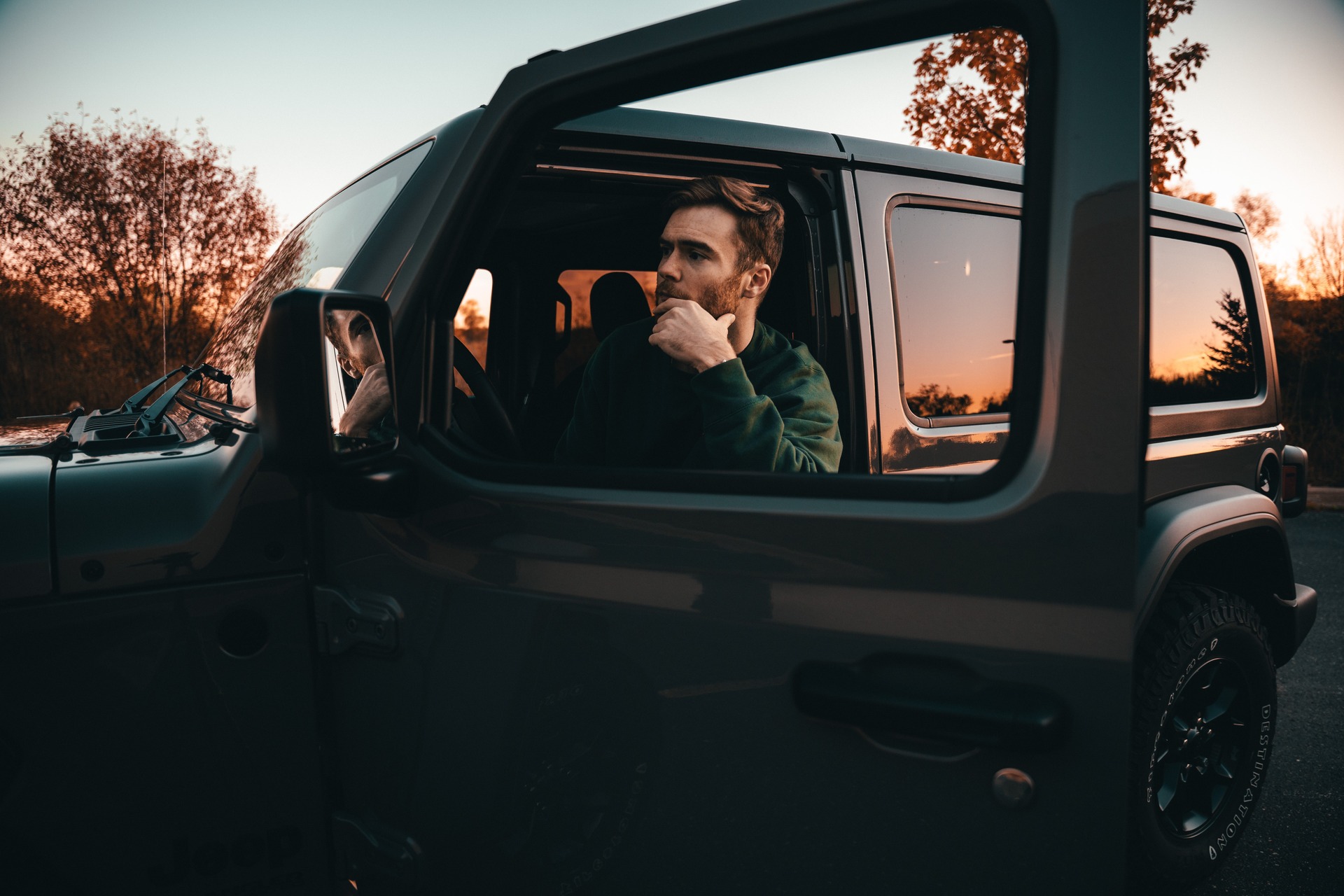 man pondering while sitting in his car
