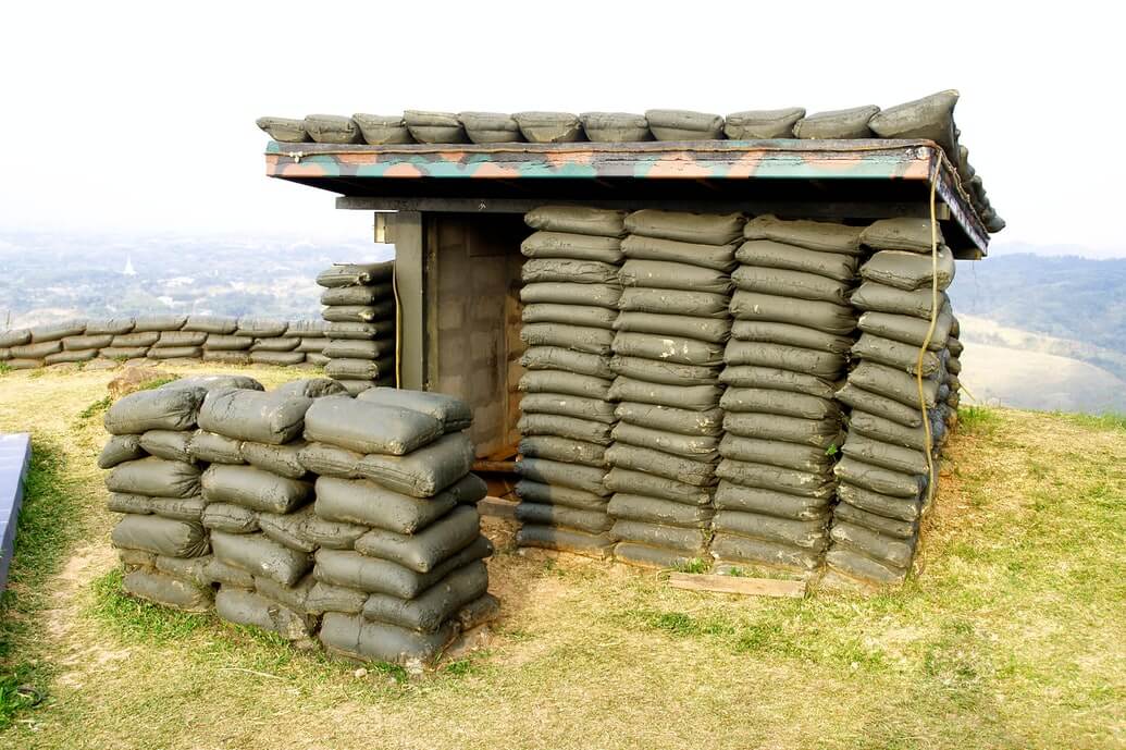 Entrance to bunker made up of green sandbags.