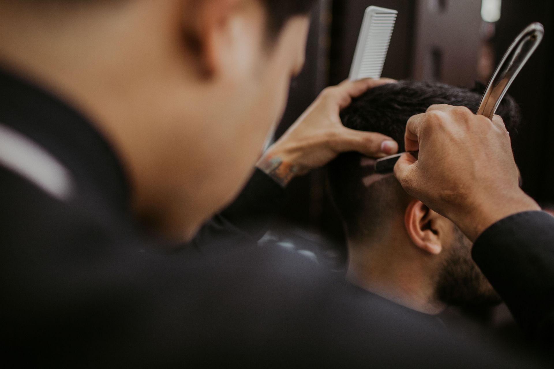Man cutting another man's hair.