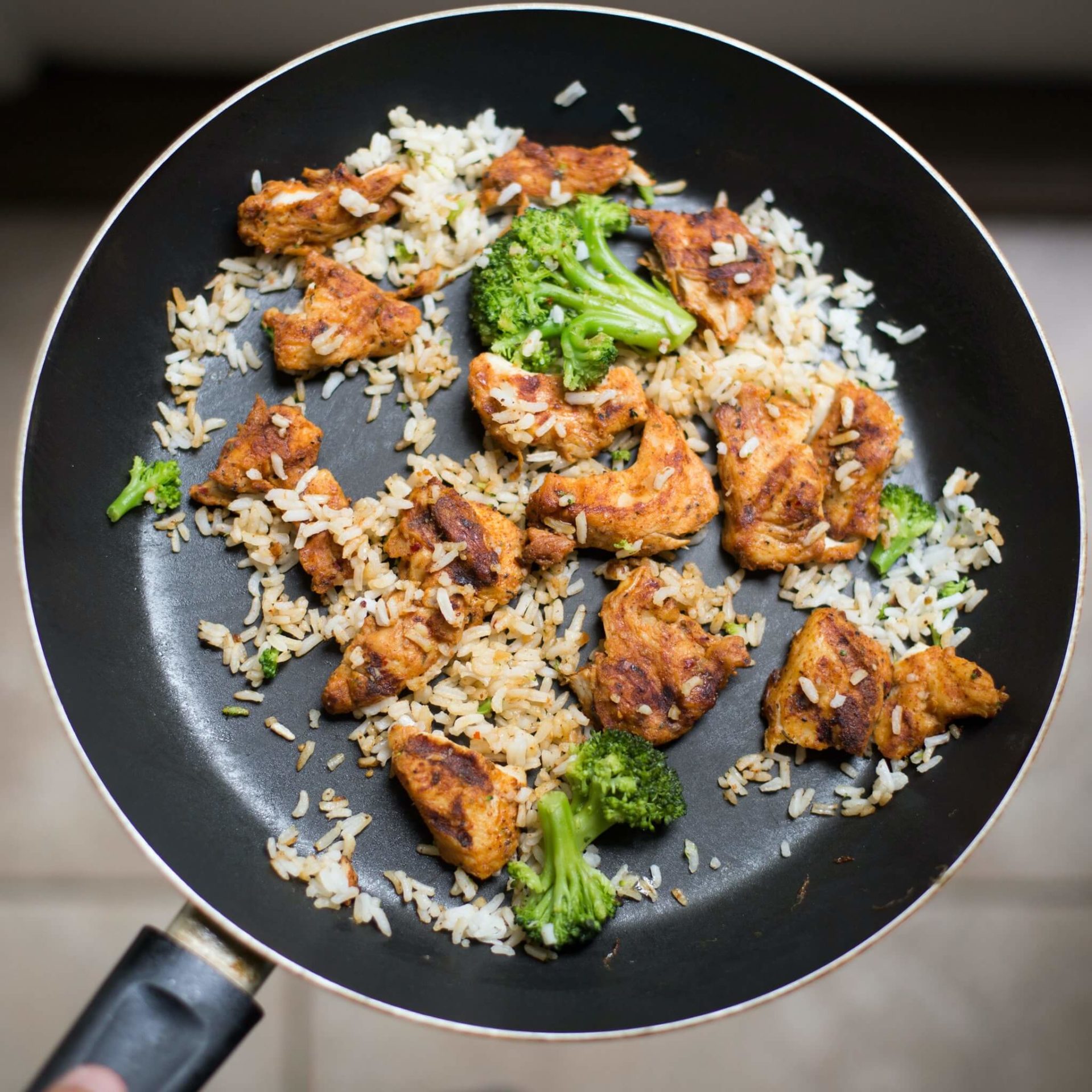 Chicken, rice and broccoli in a pan.