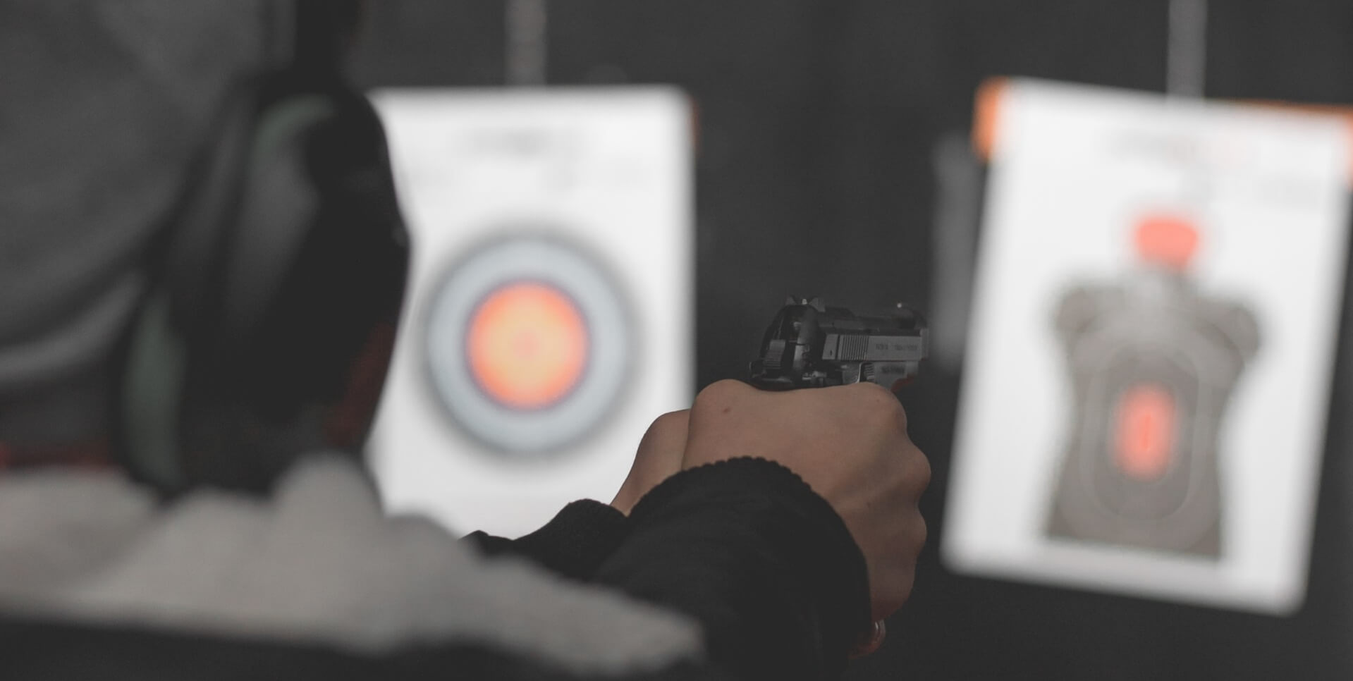 Man shooting handgun at target.