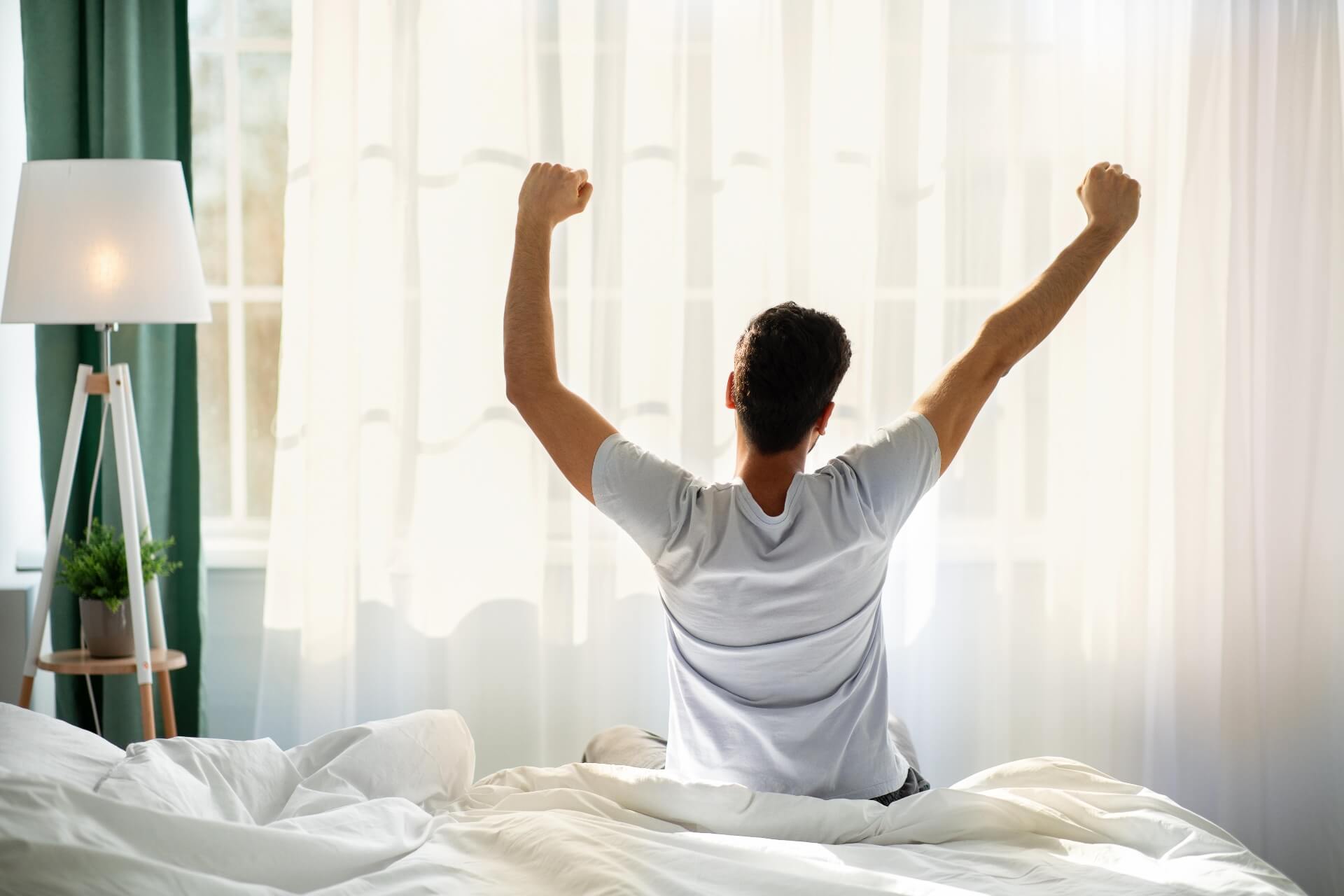 Man in white shirt stretching arms in the morning.