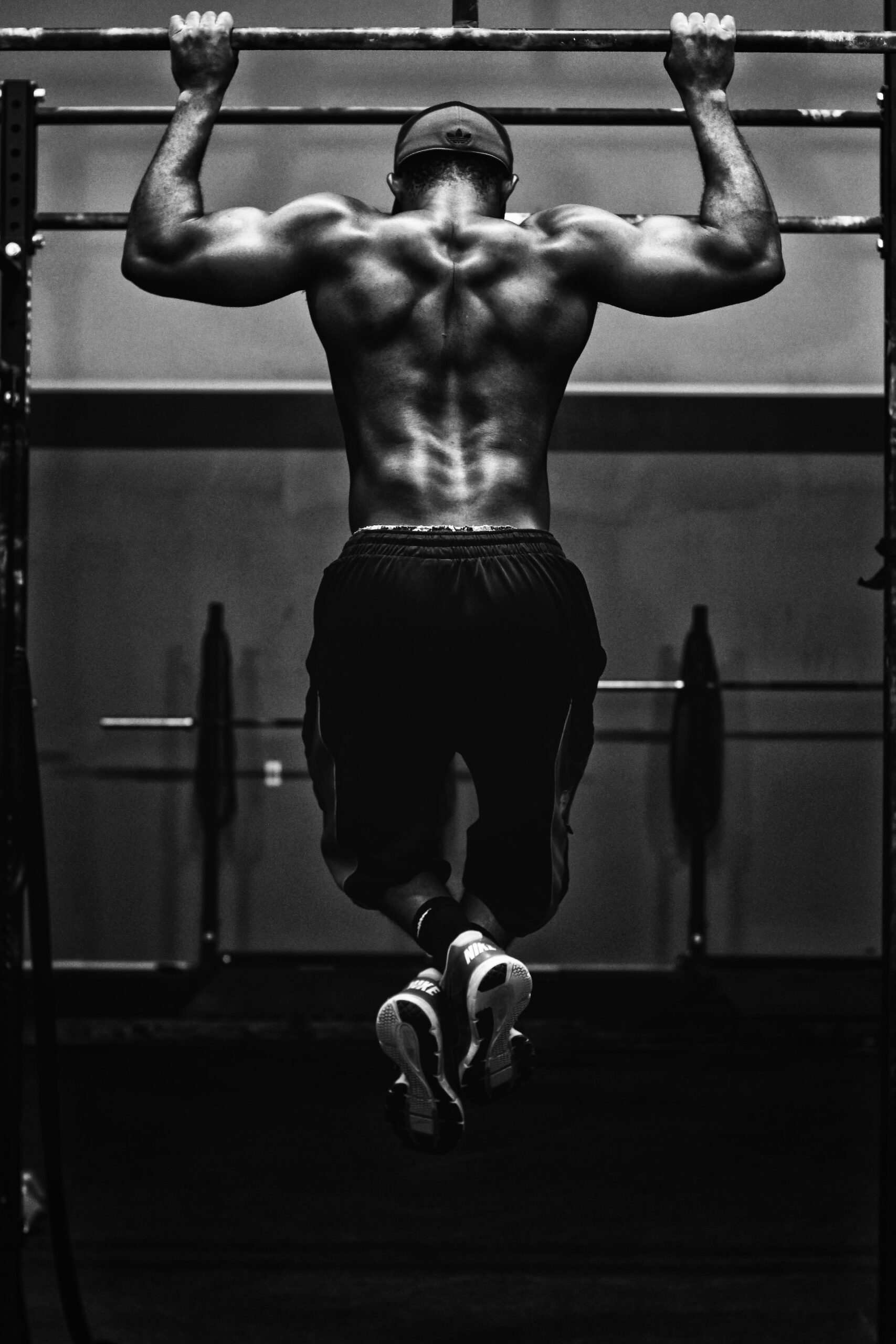 Man exercising by doing pull ups on bar.