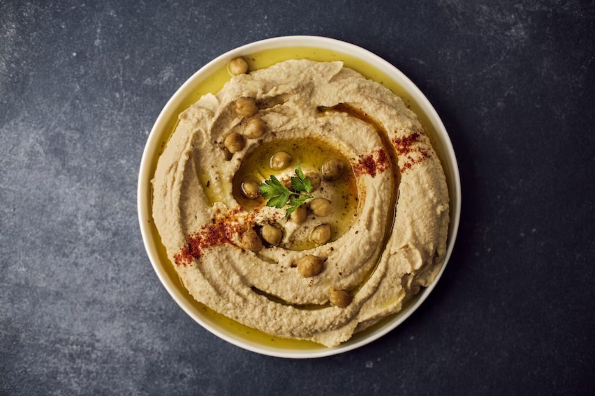 A bowl of hummus with spices and roasted chickpeas, one of the diabetes-friendly snacks listed in the post.