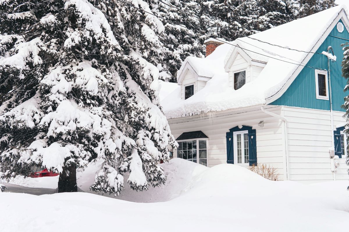 A cute home and yard covered in snow in need of an electric snow shovel.