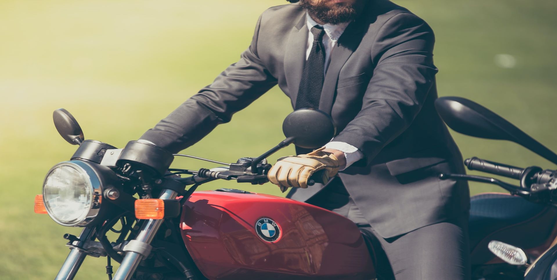 Man in suit on red motorcycle.
