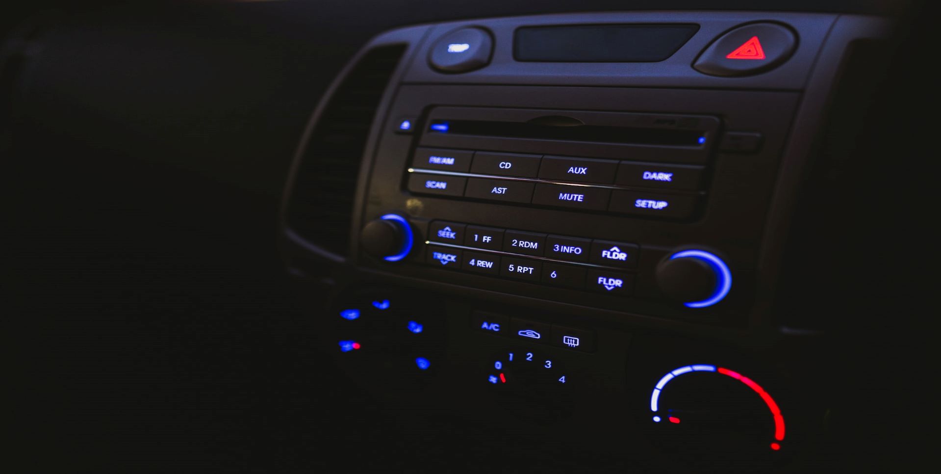 Car dashboard with lit-up buttons.