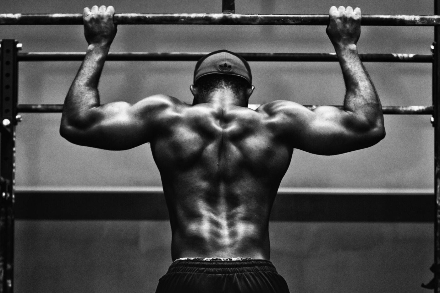 Rear view of a heavily muscled man doing pull ups