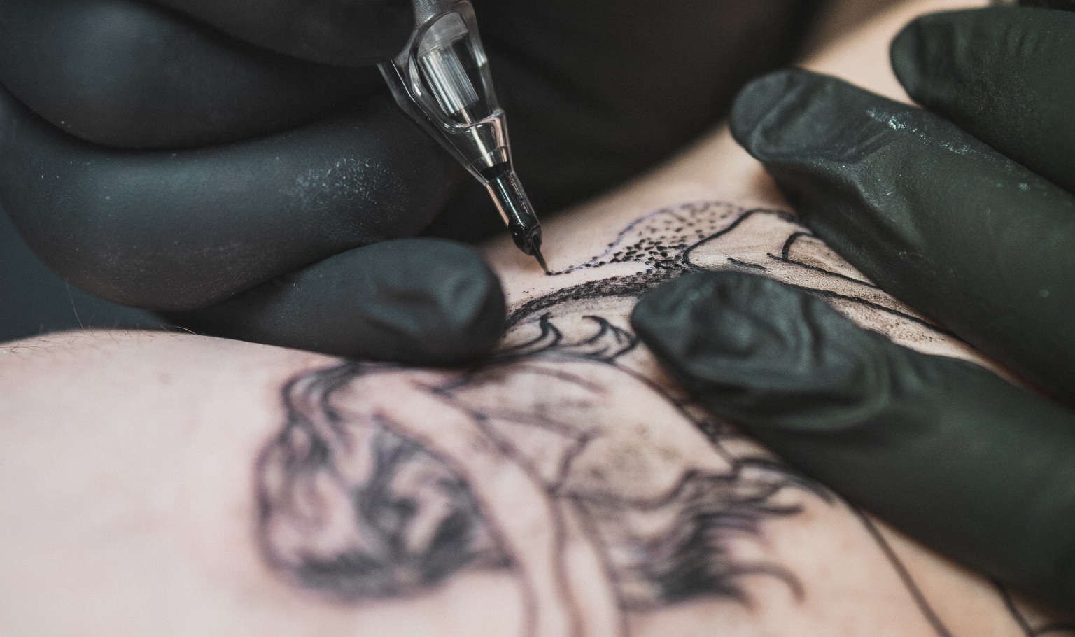 A closeup of an arm getting a tattoo.