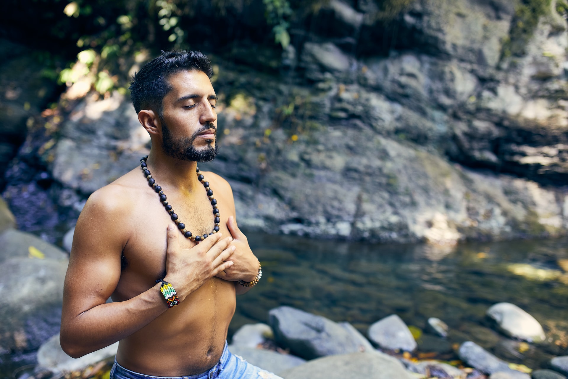 Man meditating in creek.
