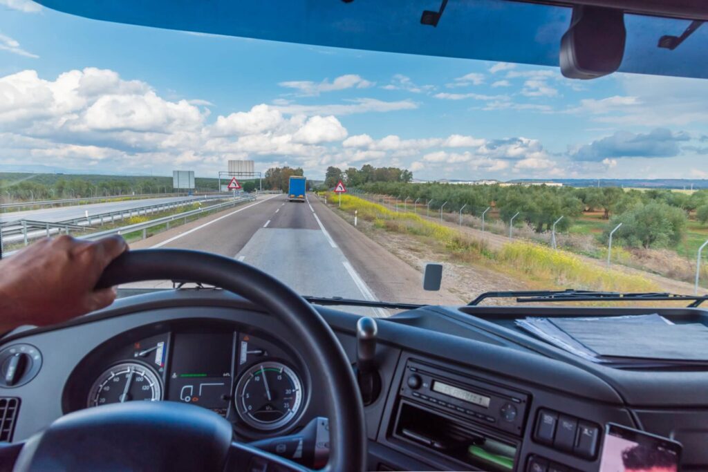 POV, behind the wheel of a truck on a clear day.