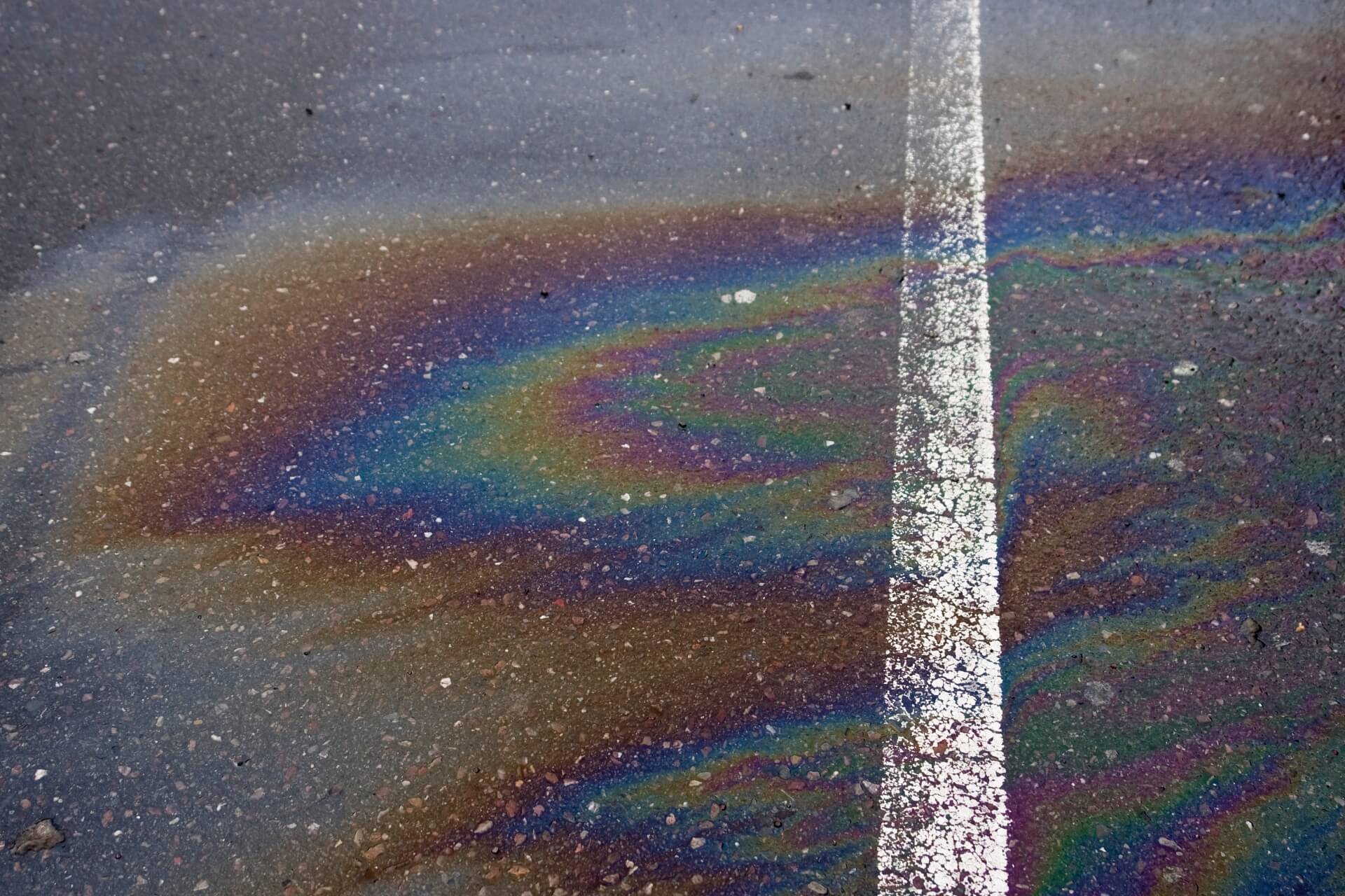 Multicolor diesel spill on asphalt.