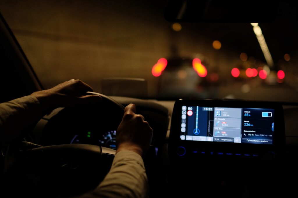 A person driving at night with a dashboard GPS