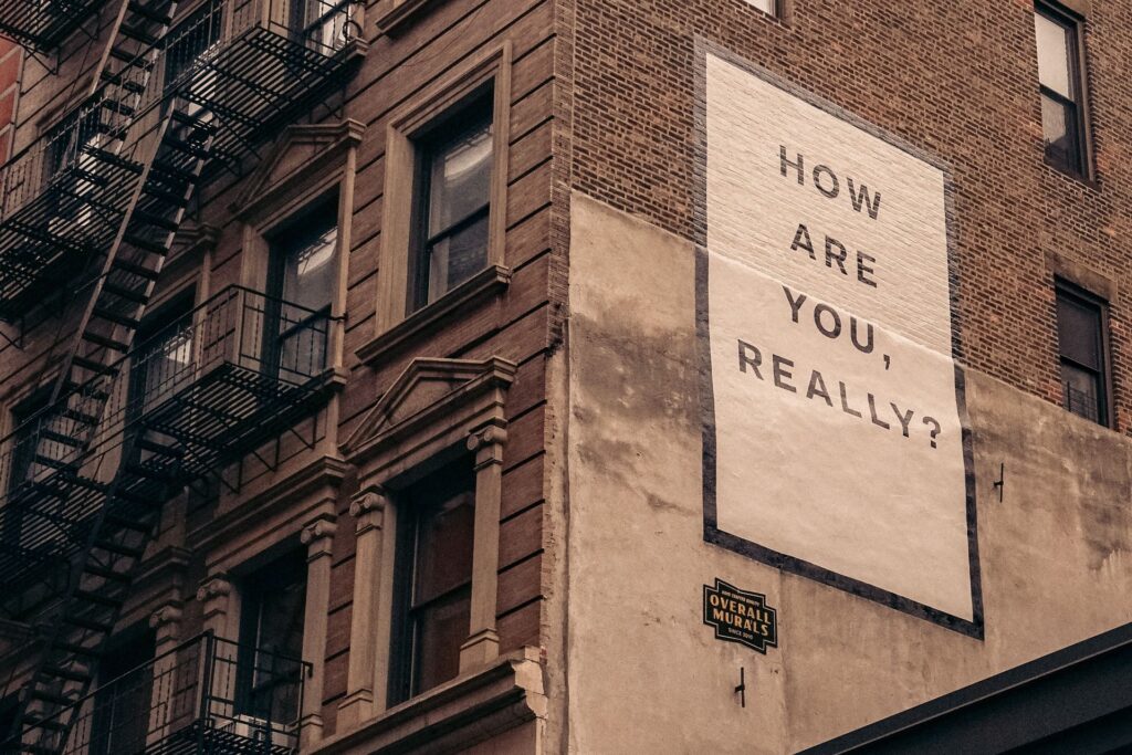 a building sign saying "how are you really?"