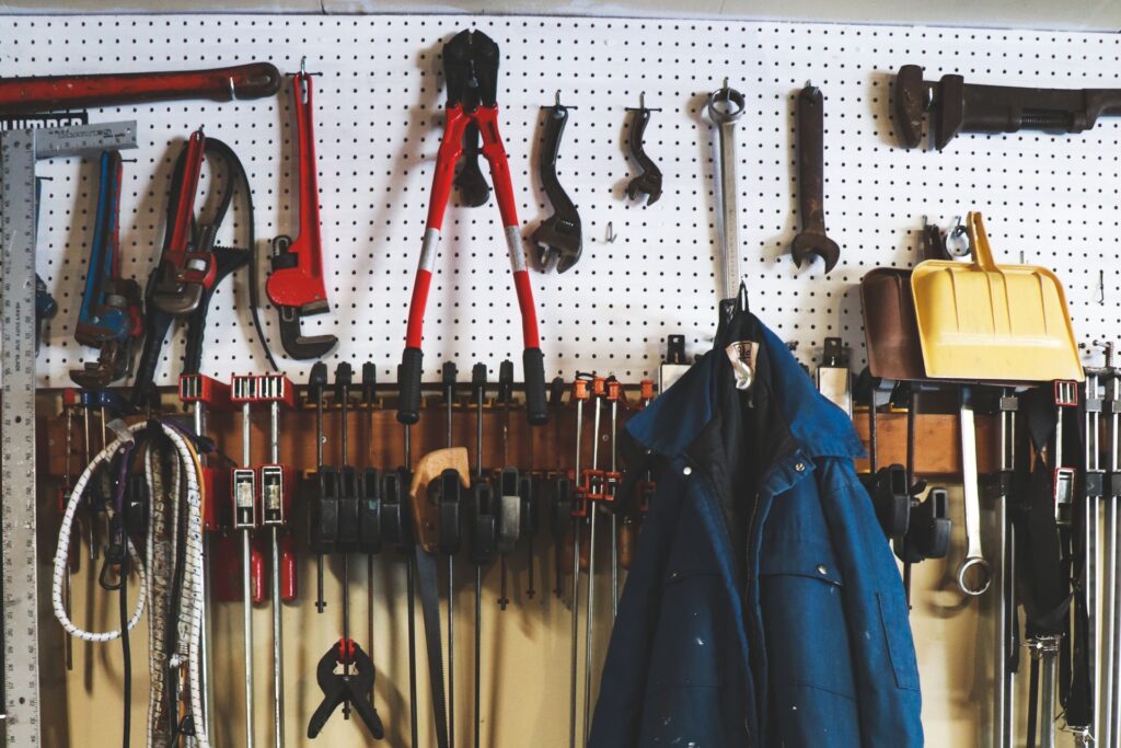 A pegboard with many different garage tools