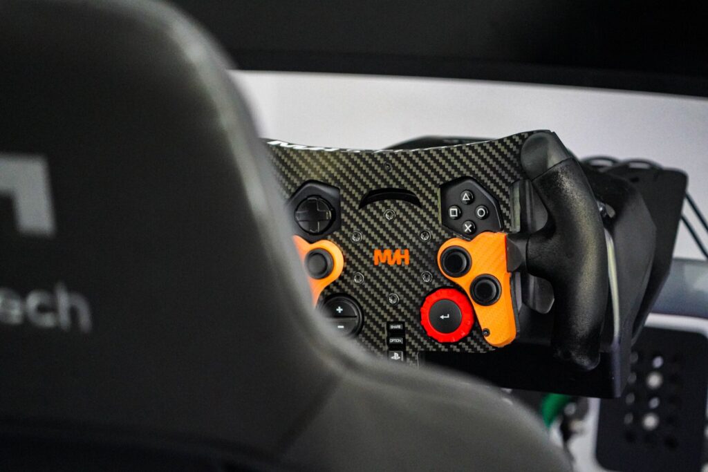 Sim racing setup with steering wheel and racing seat.