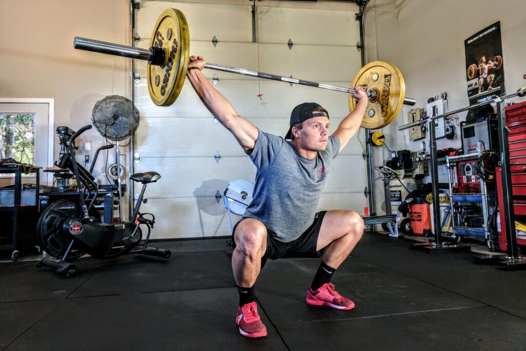Compound movements like the “snatch” exercise pictured above put your lower back, shoulders and knees in vulnerable positions, which can lead to a devastating injury without proper form.