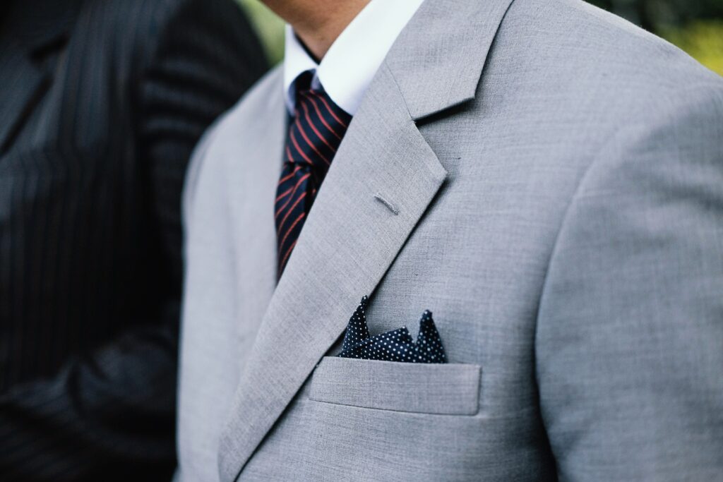 A close up of a man's dotted navy blue pocket square