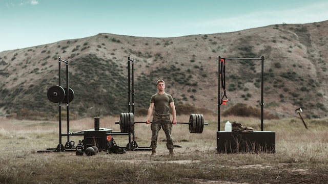A Marine lifting weights outdoors.