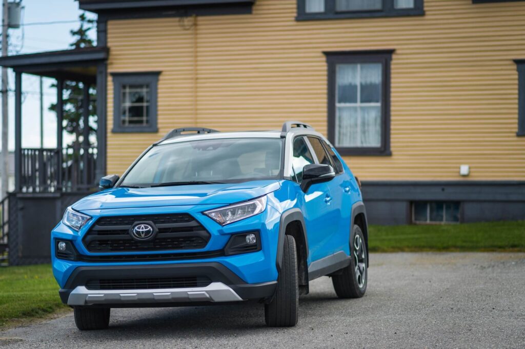 Blue Toyota RAV4 parked in a driveway.