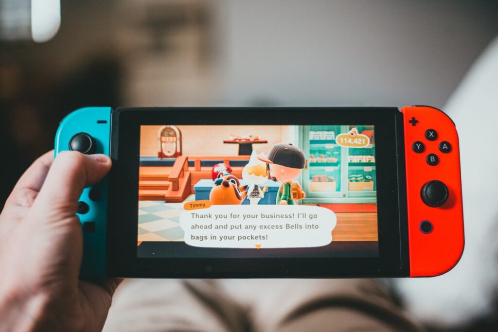 Hands holding a Nintendo Switch playing Animal Crossing: New Horizons. 