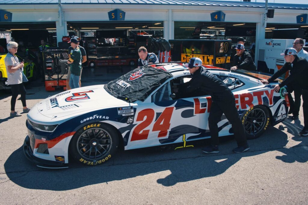 William Byron's team pushes his car in the garage. 