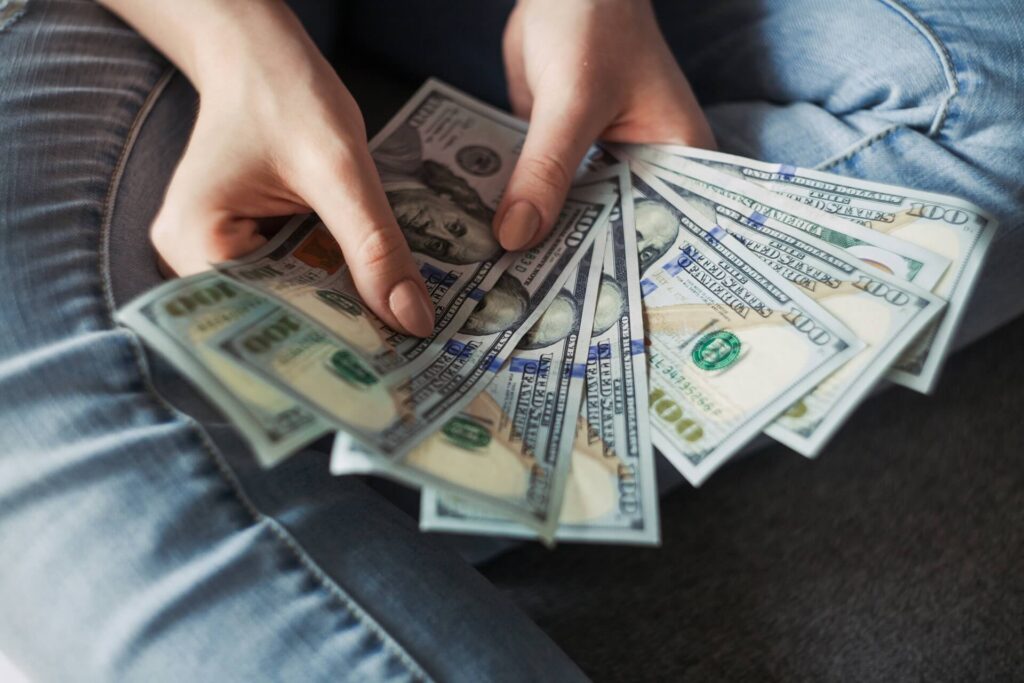 Woman holding $100 bills