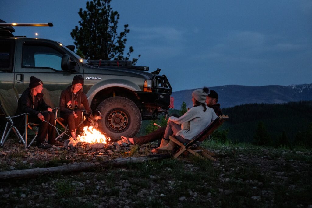 Group of friends enjoying car camping at night