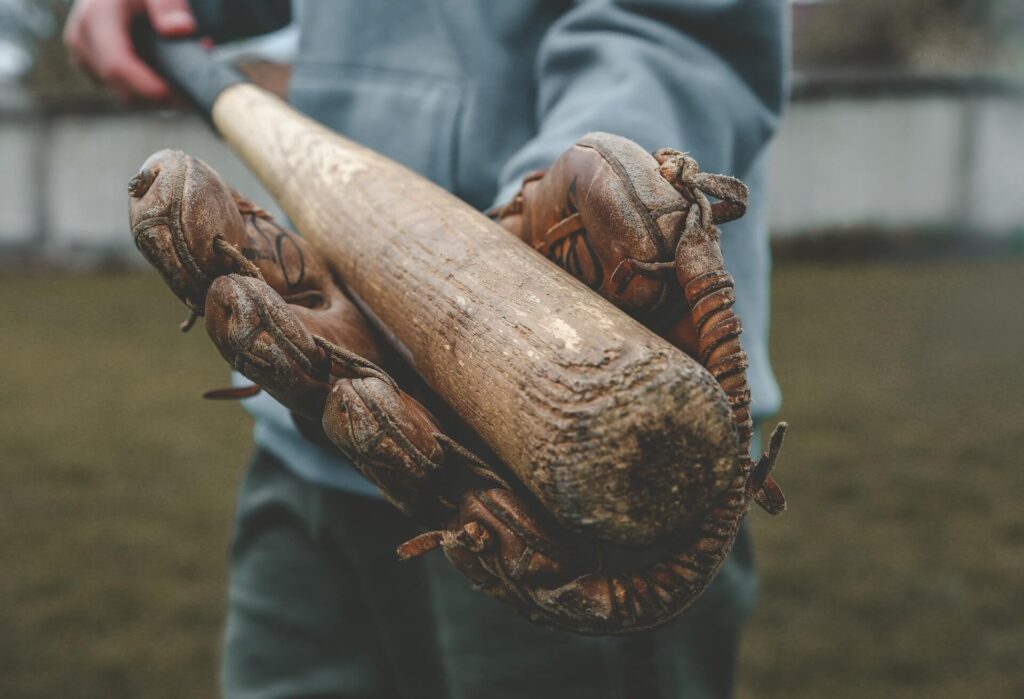 Player holds their baseball bat in between their baseball glove