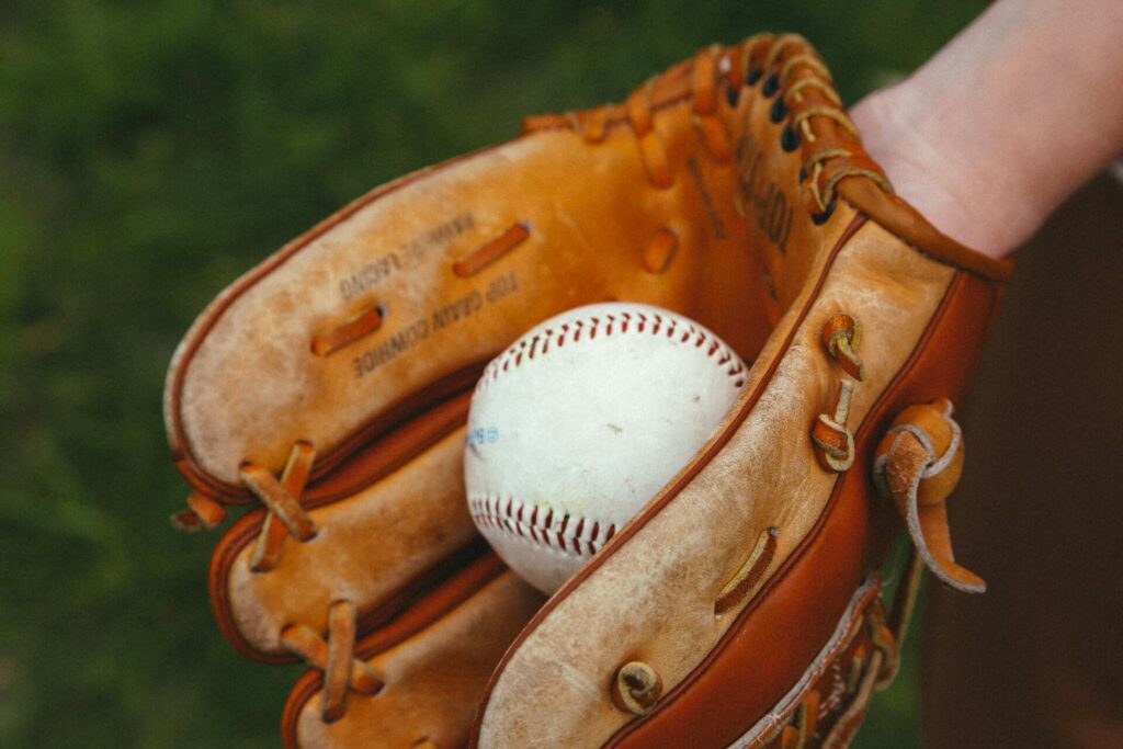 Light brown baseball glove holds a baseball