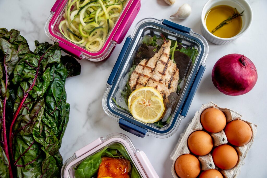 Meal-prep containers with grilled chicken, zucchini and eggs.