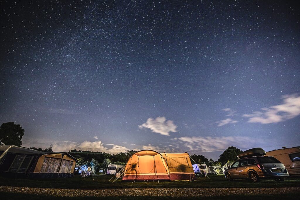 Orange tent at a campsite under the starry skies