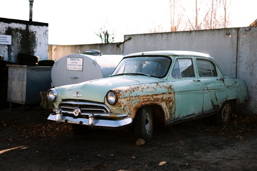 Rusty car sitting in junkyard