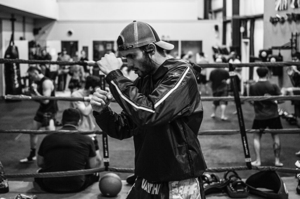 A man listening to music while working out at a boxing gym
