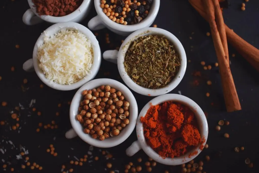Six cups of various seasonings.
