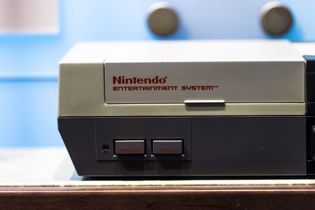 A Nintendo Entertainment System on a brown shelf. 