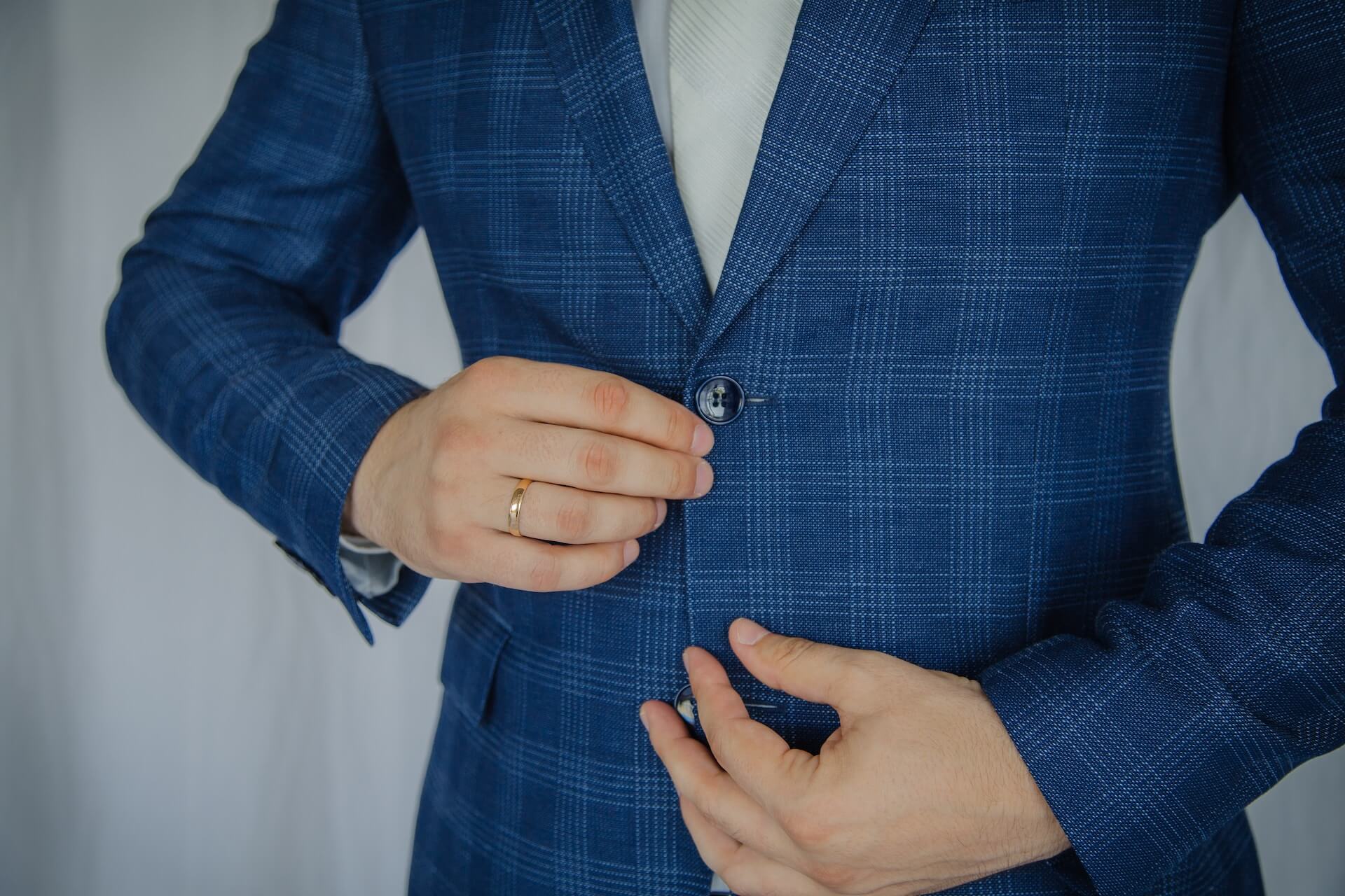 man wearing a blue blazer with sew-threw button