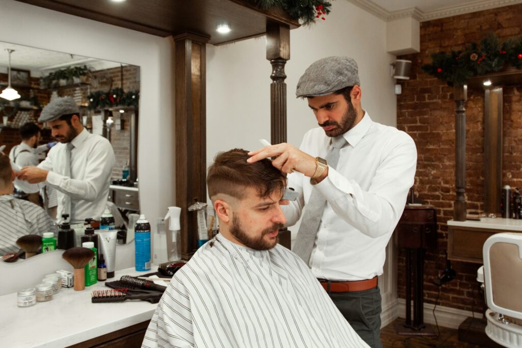 A man getting a Roger Sterling haircut with thin sides and longer hair on top