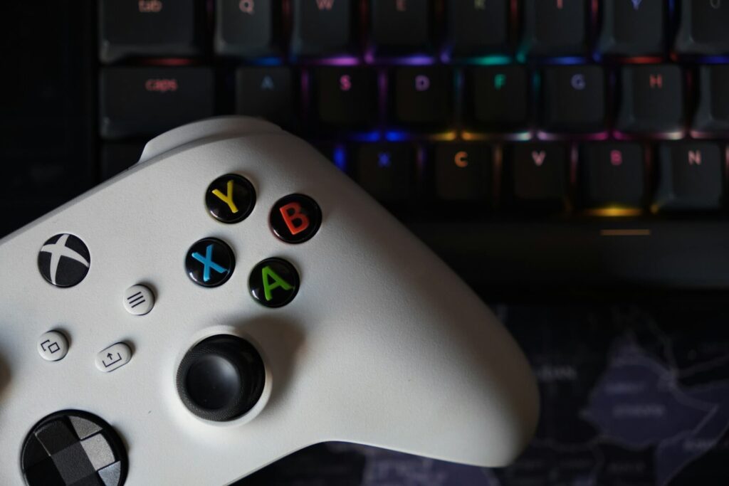 A white Xbox controller on top of a keyboard.