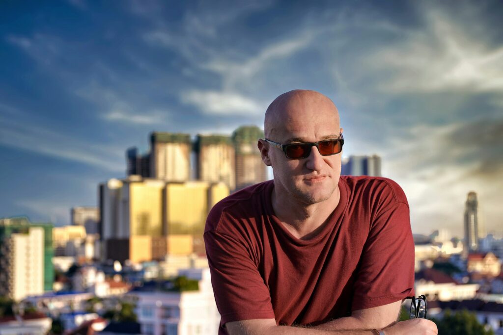 A confident man with a shaved head and sunglasses