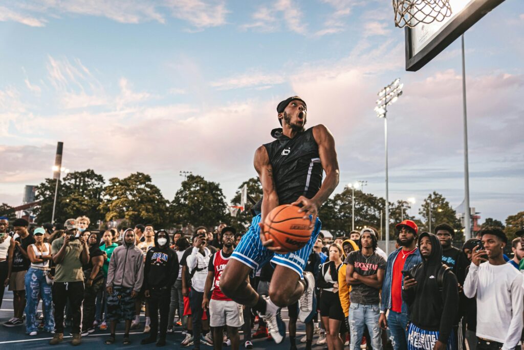 a small forward dunking in front of a group of onlookers