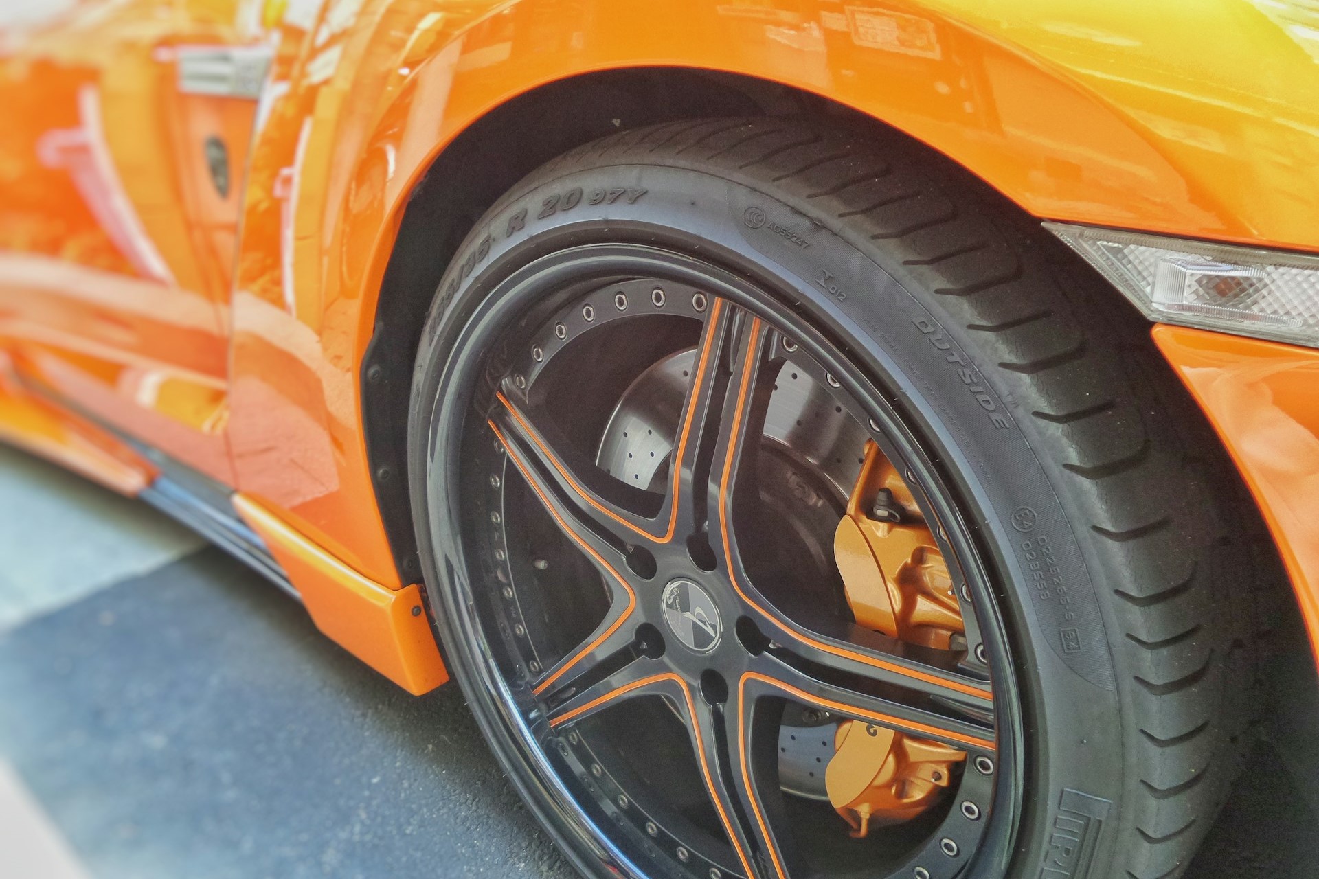 The tire of a neon orange car