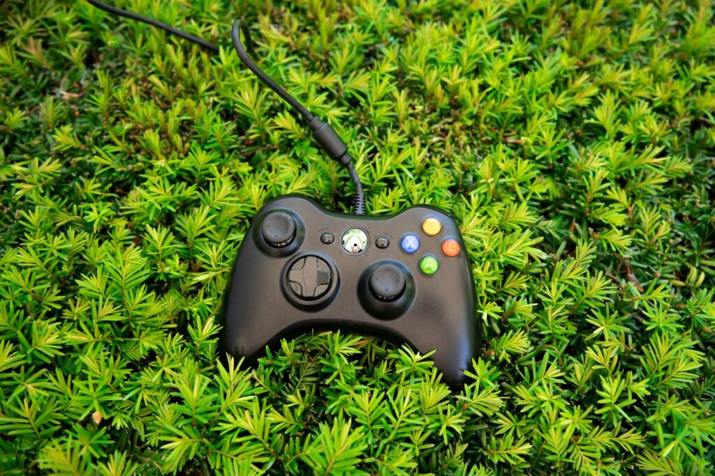 Black Xbox 360 controller on grass