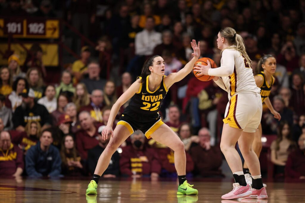 Caitlin Clark playing defense against a Minnesota player.