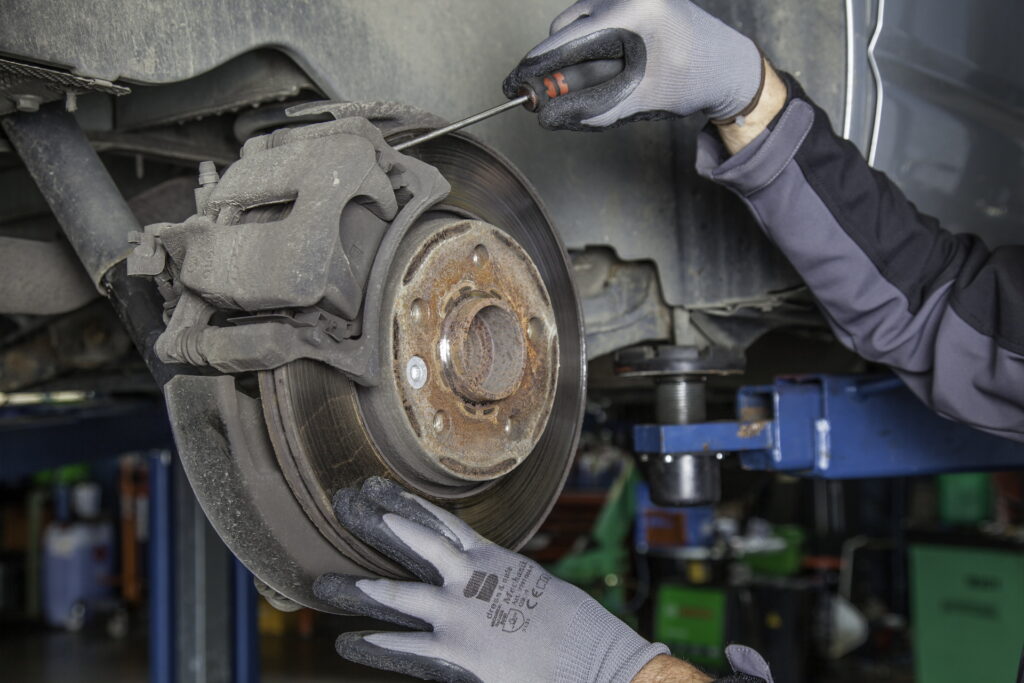 A rusted brake pad being removed